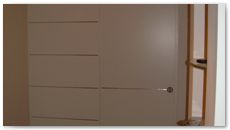 Arredamento in legno: porta scorrevole laccata con paretina e inserti alluminio